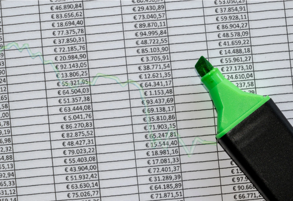 Excel-Tabelle mit hohen Beträgen und grünem Textmarker, der eine sinkende Kurve markiert – verdeutlicht die Grenzen manueller Tabellen-Auswertungen und den Vorteil automatisierter Berichte im prima ERP-System.
